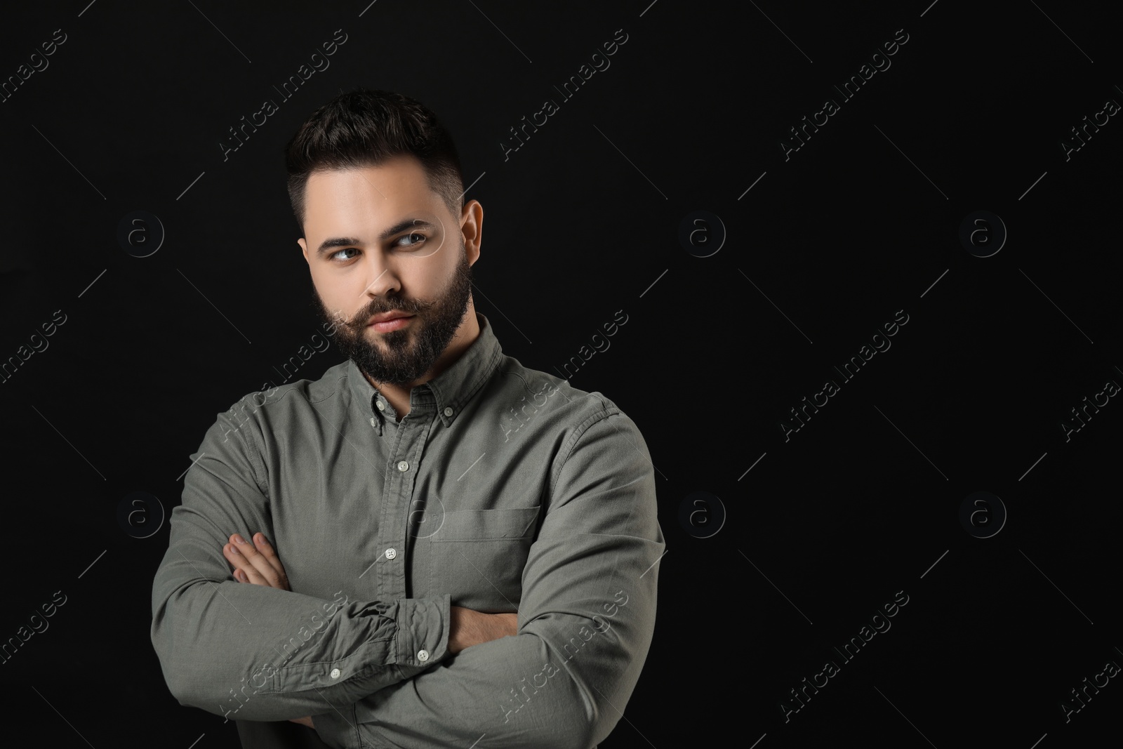 Photo of Portrait of young man with mustache on black background. Space for text