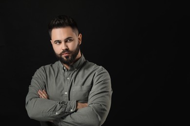 Portrait of young man with mustache on black background. Space for text