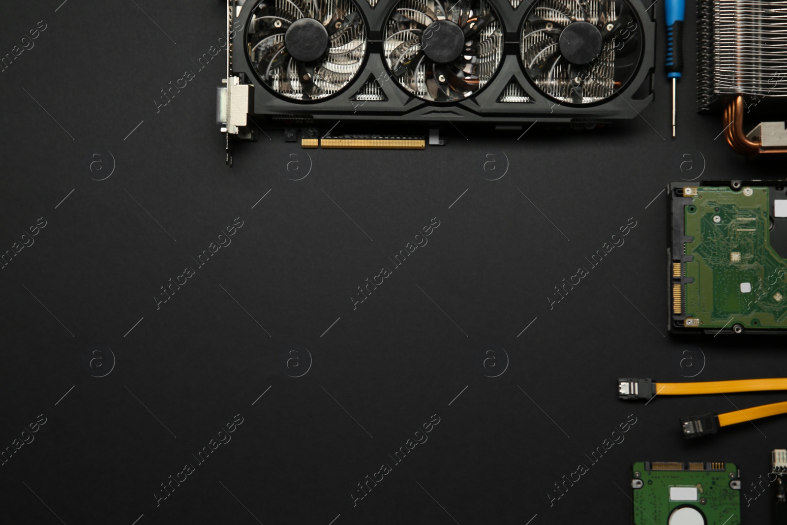 Photo of Graphics card and other computer hardware on black background, flat lay. Space for text