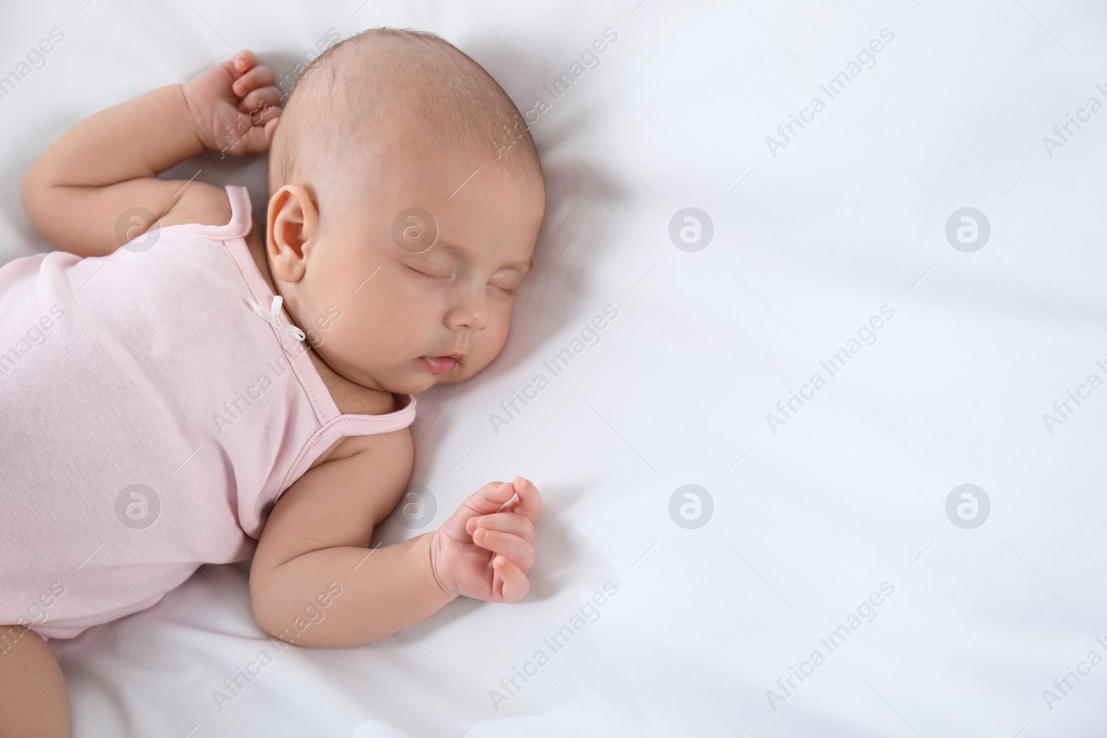 Photo of Cute little baby sleeping on bed, above view. Space for text
