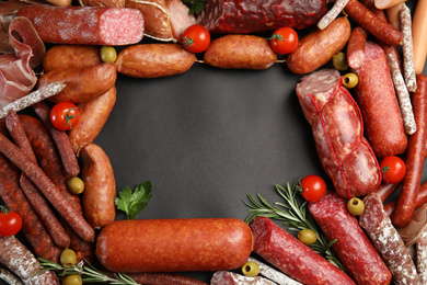 Frame made of different sausages on black background, flat lay. Space for text