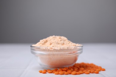 Bowl of lentil flour and seeds on white table, space for text