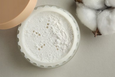 Photo of Rice loose face powder and cotton flower on light grey background, flat lay