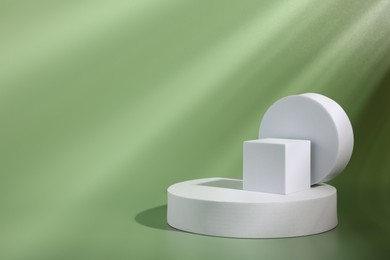 Photo of Product presentation scene. Figures of different geometric shapes on pale light green background, space for text
