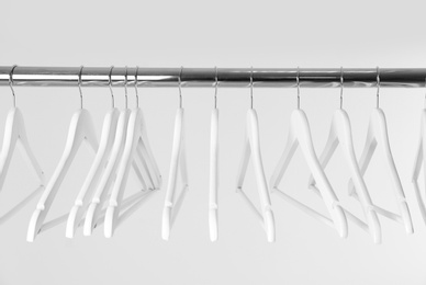 Metal rack with clothes hangers on white background