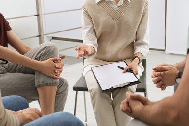 Photo of Psychotherapist working with group of drug addicted people at therapy session indoors, closeup