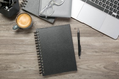 Flat lay composition with notebooks and laptop on wooden table