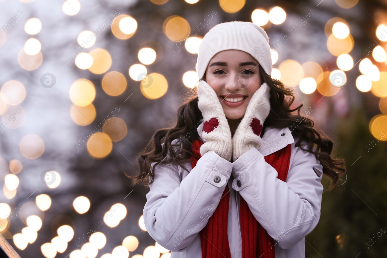 Photo of Happy young woman outdoors in evening. Christmas celebration