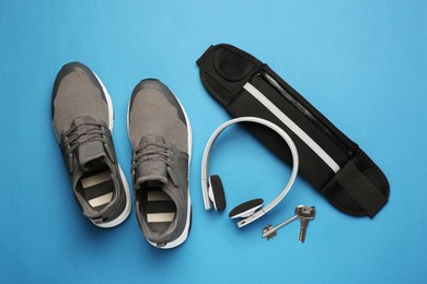 Photo of Flat lay composition with stylish black waist bag on light blue background