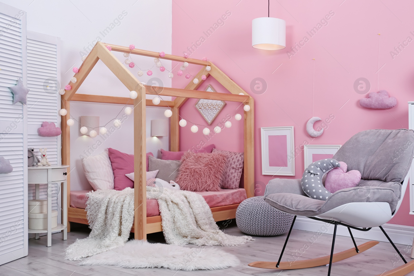 Photo of Child's room interior with comfortable bed and garland