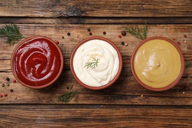 Photo of Many different sauces on wooden table, flat lay