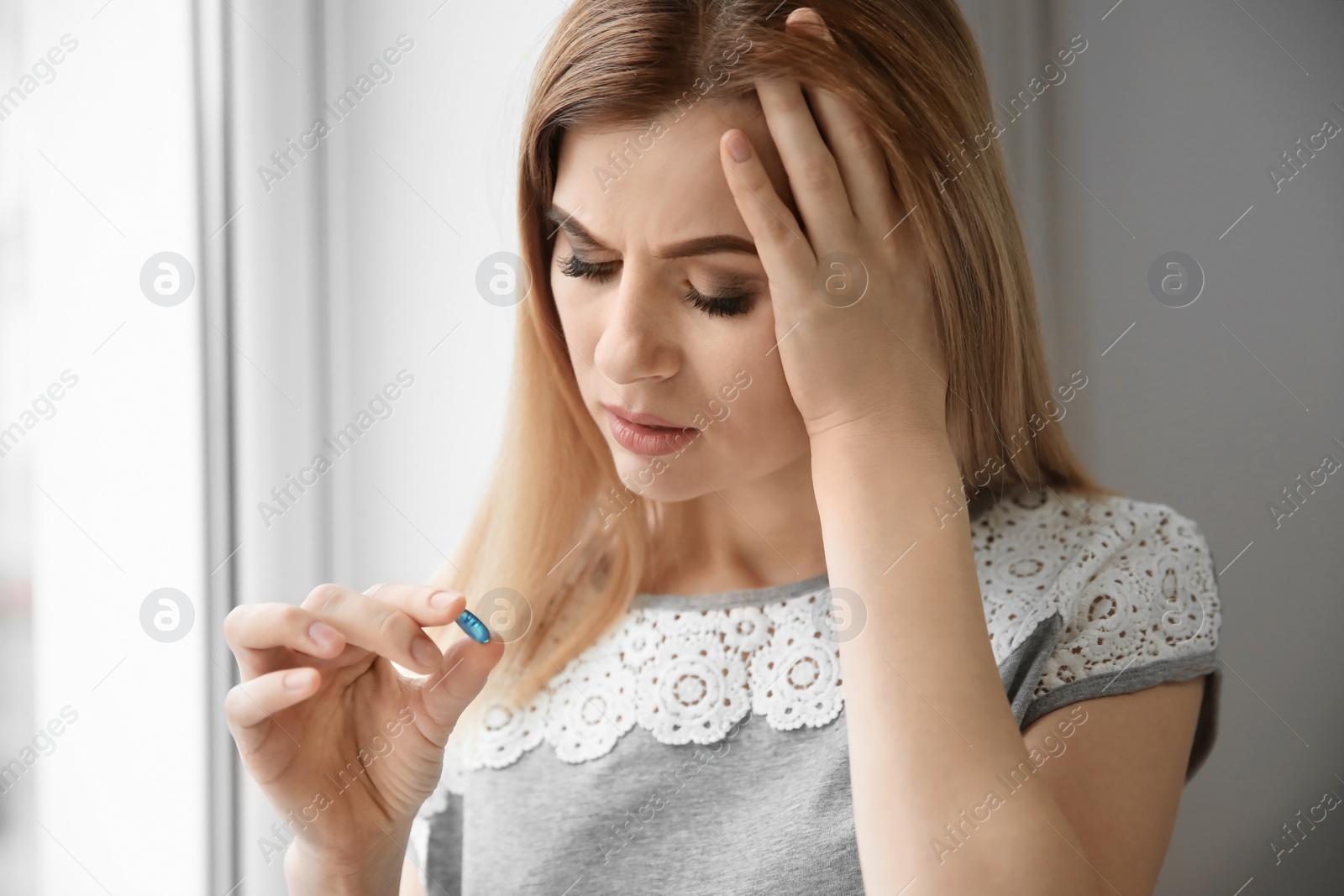 Photo of Young woman with pill indoors