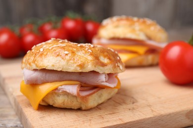 Photo of Delicious bagels with ham and cheese on table, closeup. Space for text