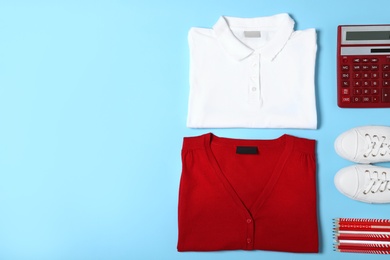 Photo of Flat lay composition with school uniform on blue background. Space for text