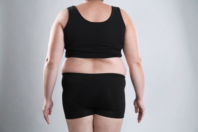 Photo of Fat woman on grey background, closeup. Weight loss