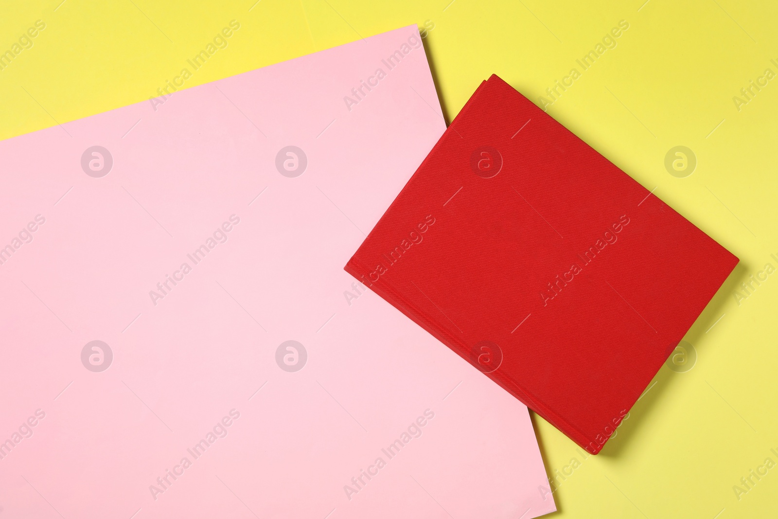 Photo of Book with red cover on color background, top view. Space for text