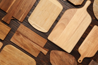 Set of wooden boards on brown table, flat lay. Cooking utensils