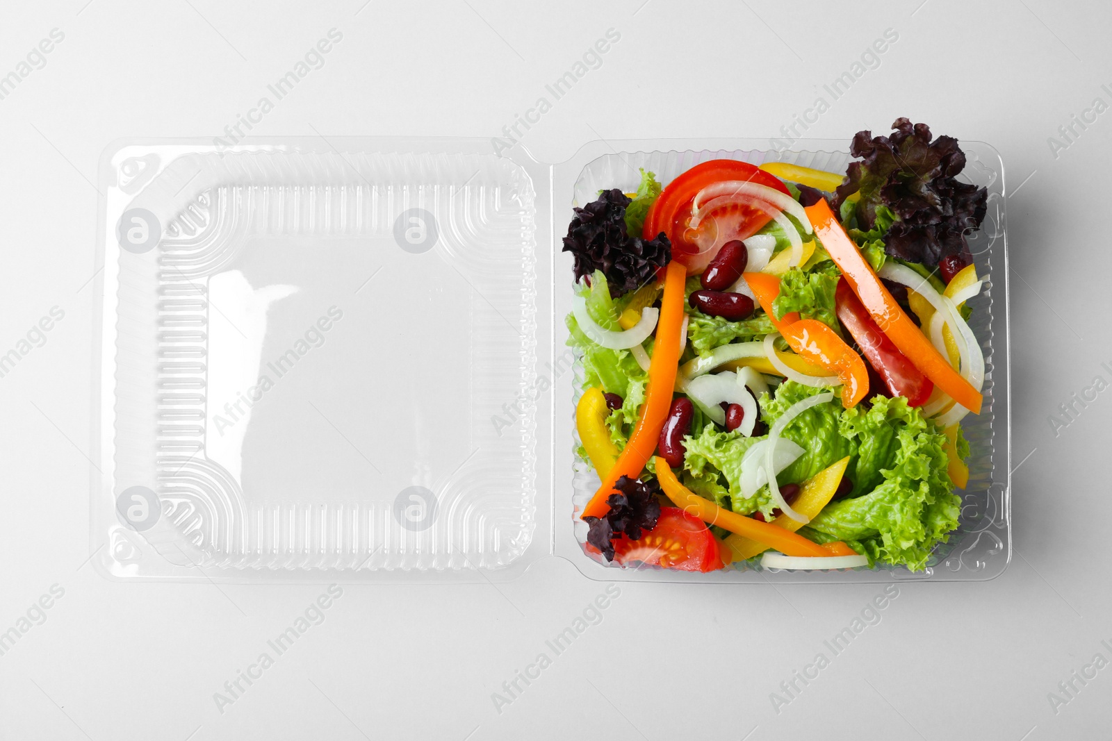 Photo of Plastic container with fresh salad on white background, top view