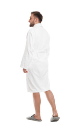 Handsome man wearing bathrobe on white background