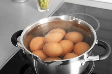 Cooking chicken eggs in pot on electric stove