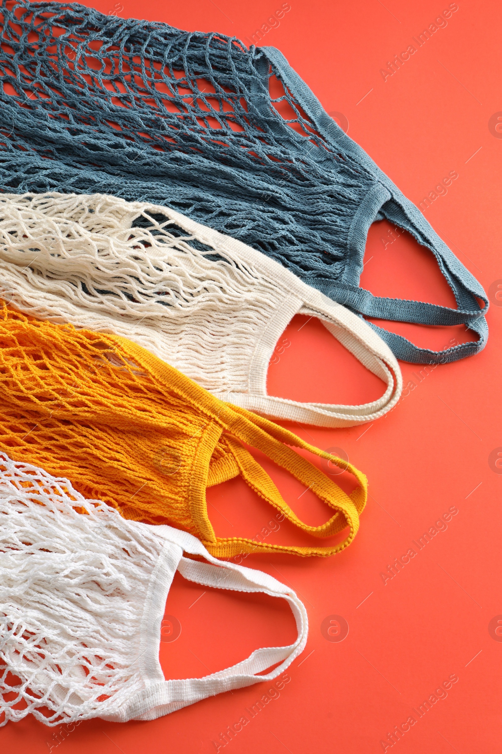 Photo of Different string bags on red background, top view