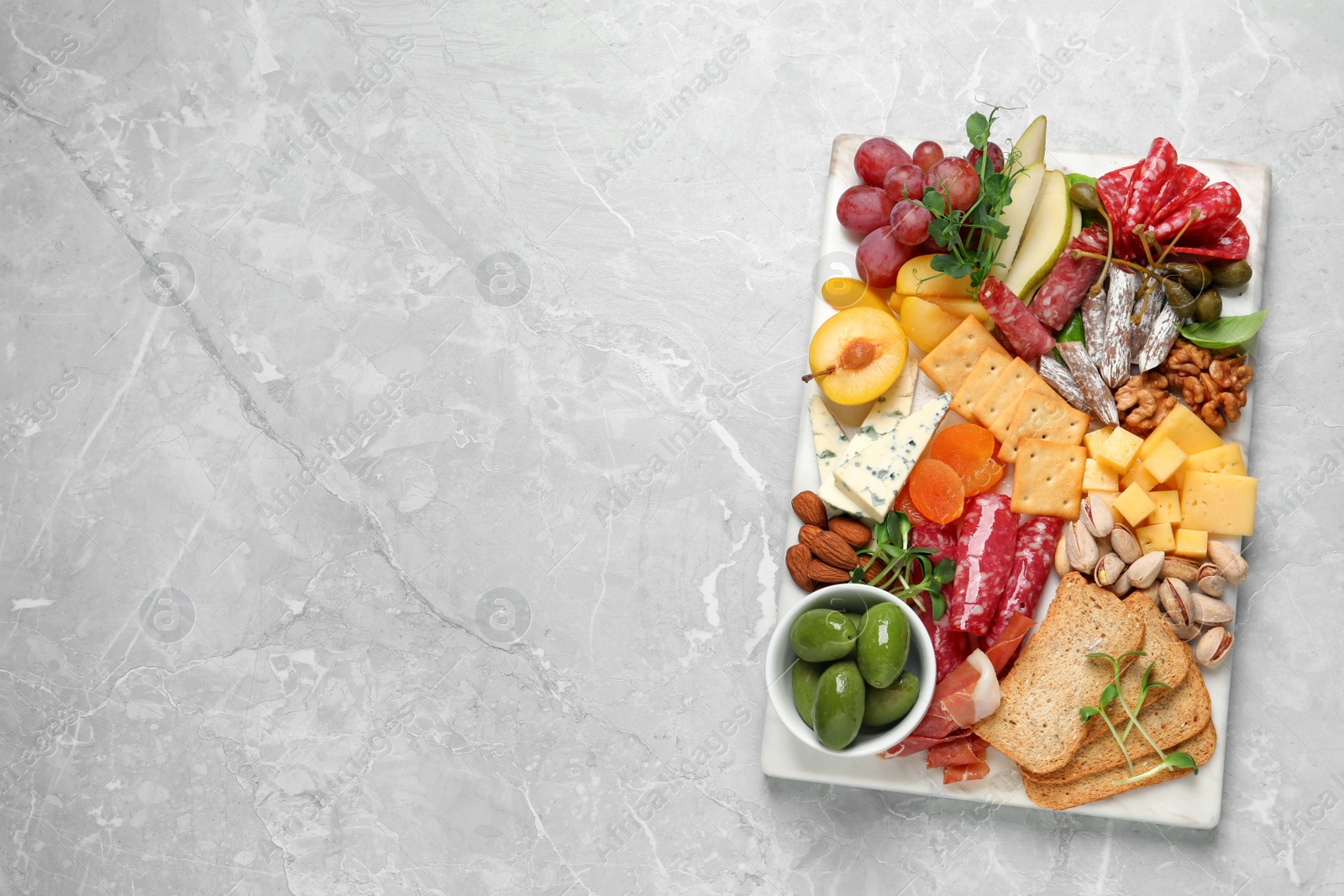 Photo of Different tasty appetizers on light marble table, top view. Space for text