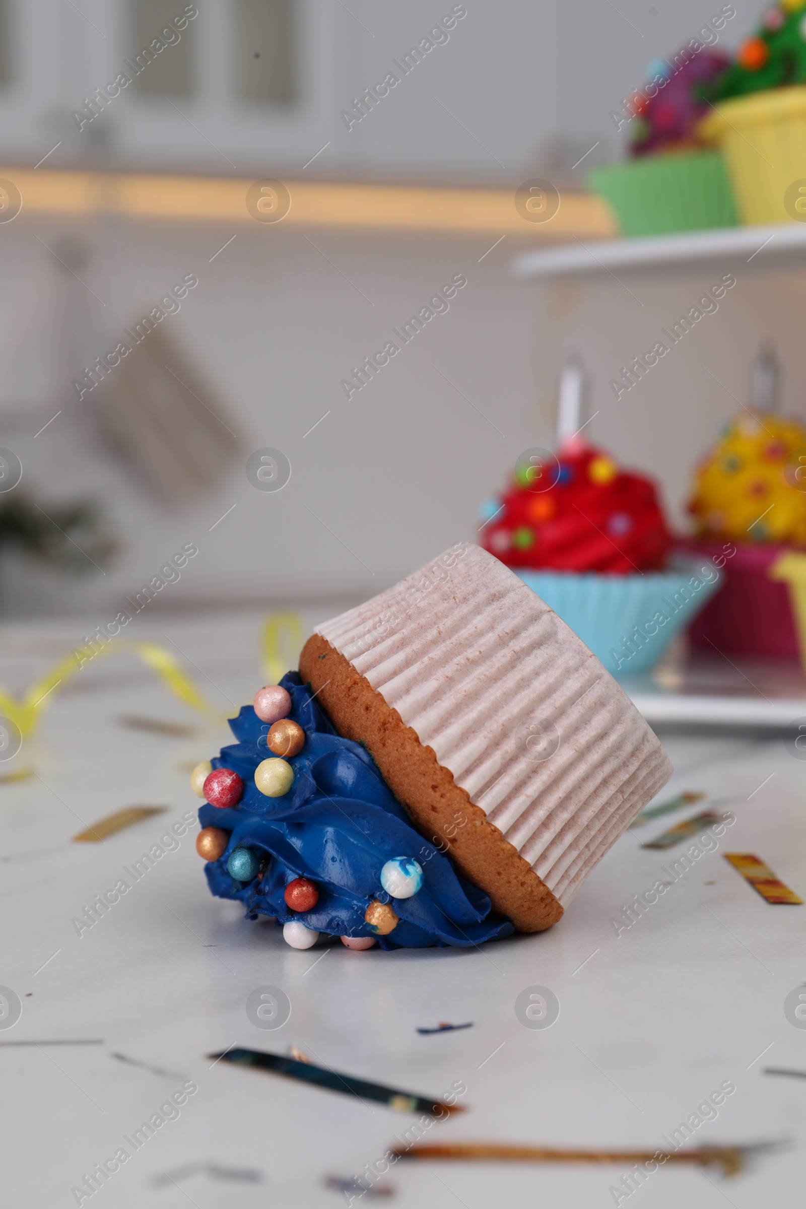 Photo of Cupcake dropped on white table, closeup. Troubles happen