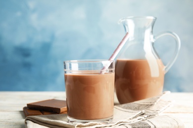 Photo of Glass of tasty chocolate milk on wooden table. Dairy drink
