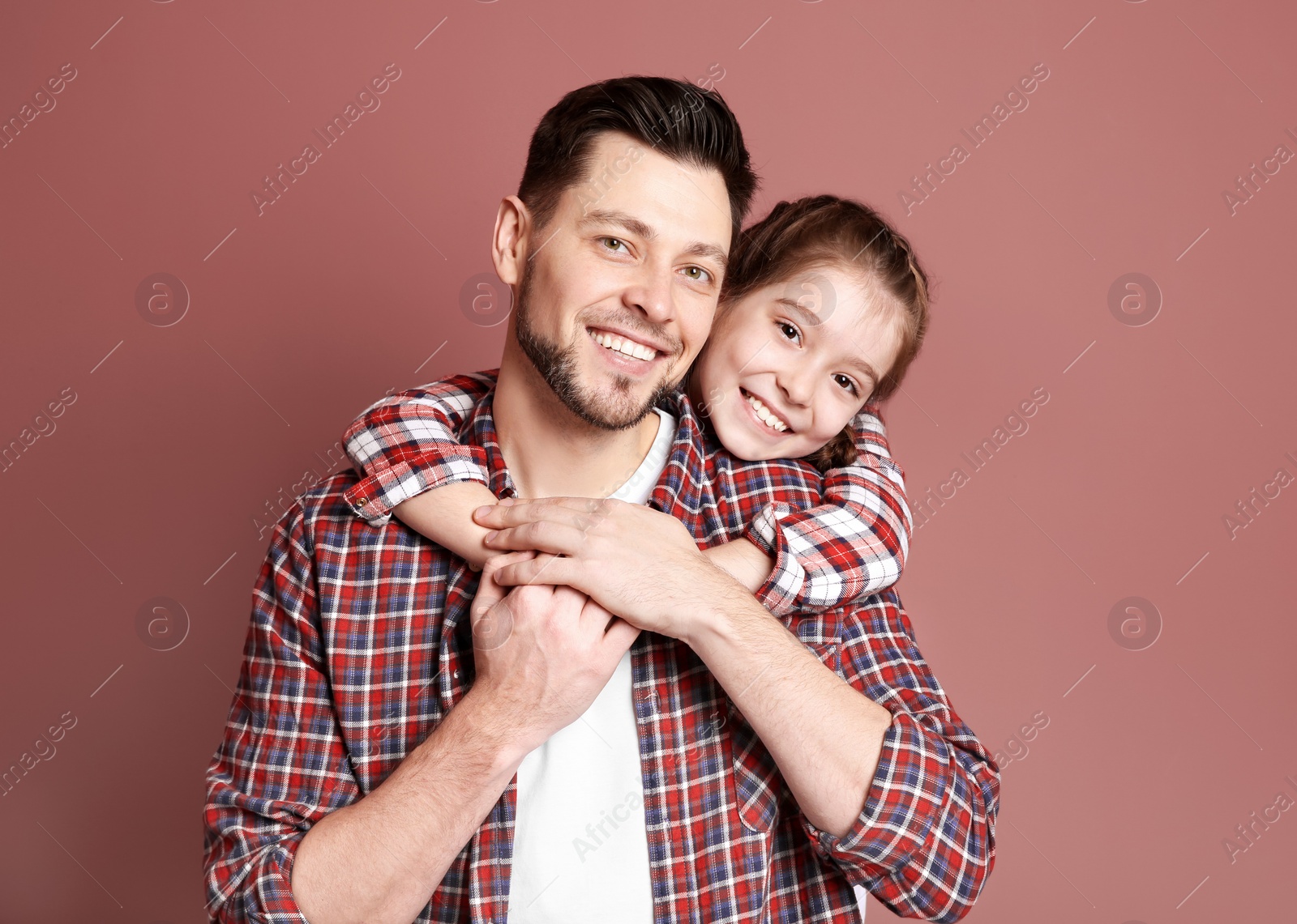 Photo of Dad and his daughter hugging on color background. Father's day celebration