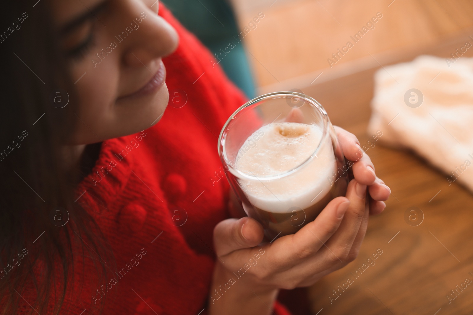 Photo of Woman with fresh morning coffee at table in cafe, closeup