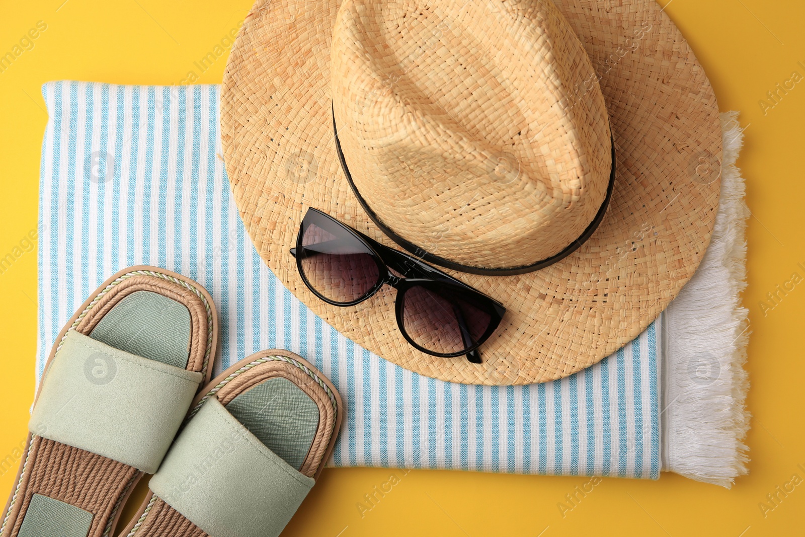 Photo of Flat lay composition with beach accessories on yellow background