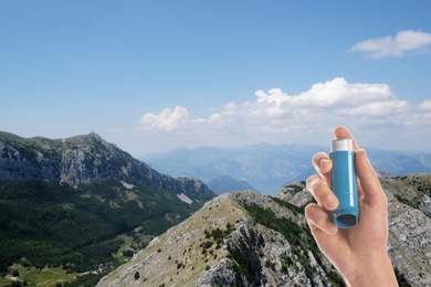 Man with asthma inhaler and beautiful mountains on background, closeup. First emergency medical aid