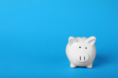 Photo of Ceramic piggy bank on light blue background, space for text. Financial savings