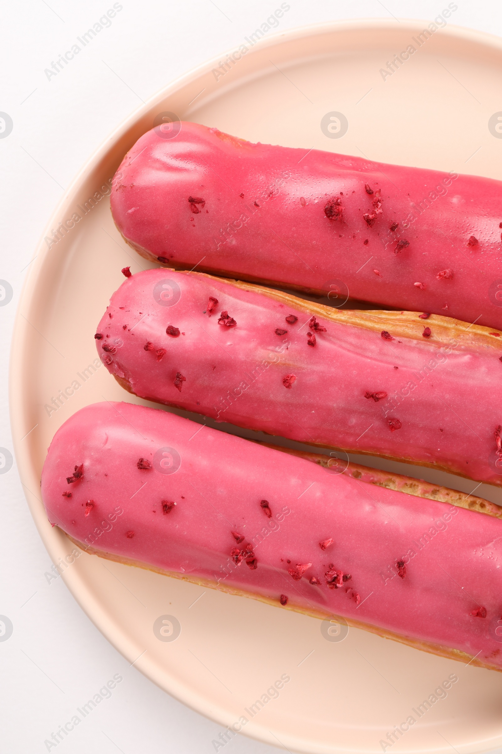 Photo of Delicious eclairs covered with glaze on white background, top view