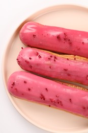 Photo of Delicious eclairs covered with glaze on white background, top view