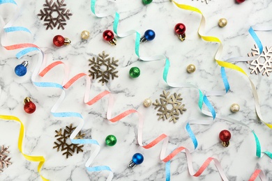 Photo of Flat lay composition with serpentine streamers and Christmas decor on white marble background
