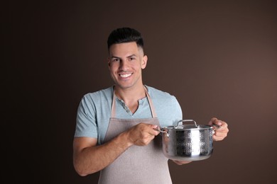 Photo of Happy man with pot on brown background