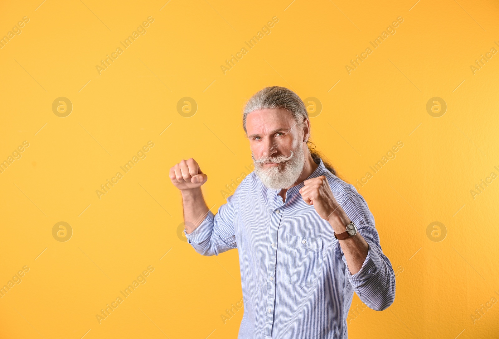 Photo of Portrait of handsome mature man on color background