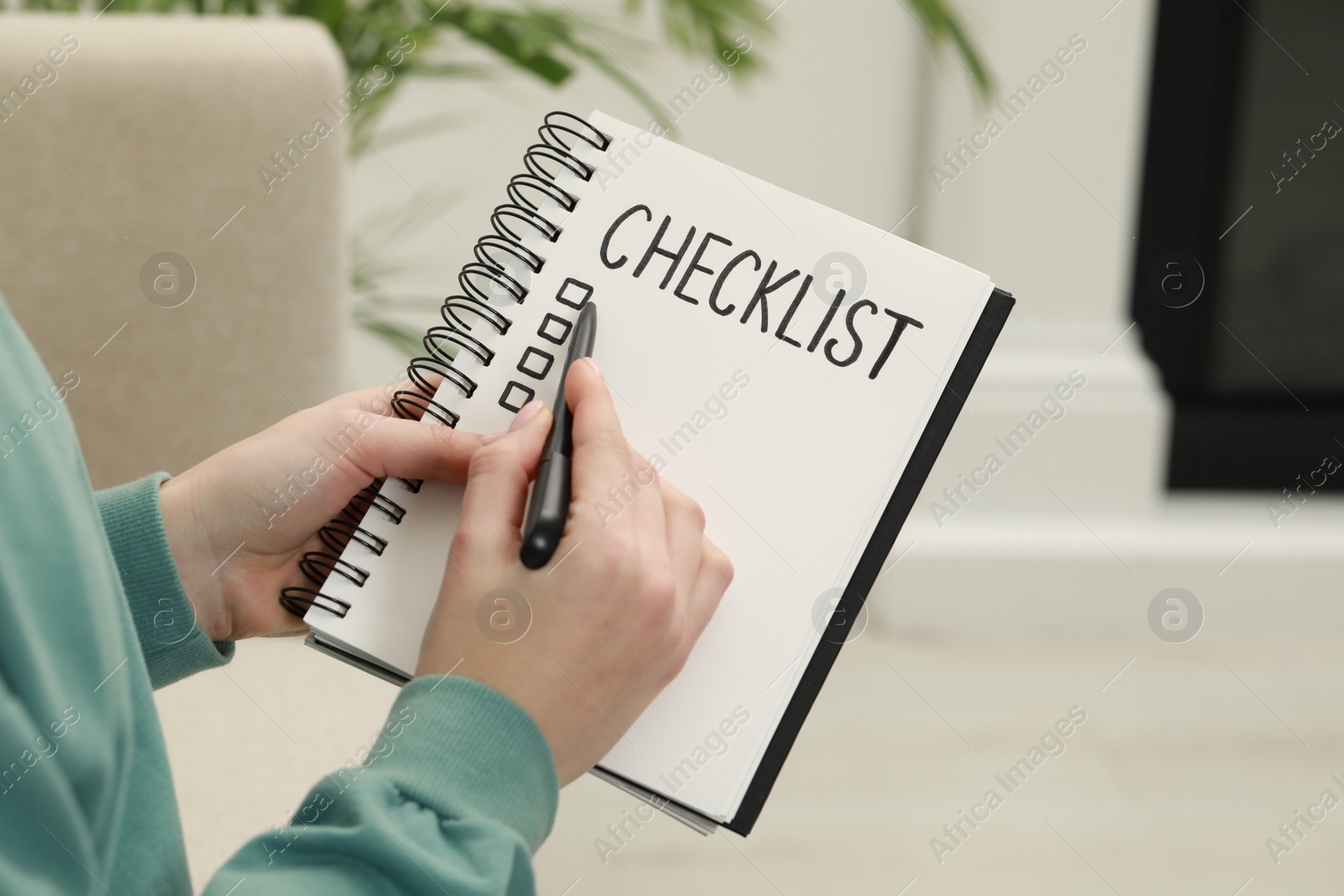 Photo of Woman filling Checklist with pen indoors, closeup