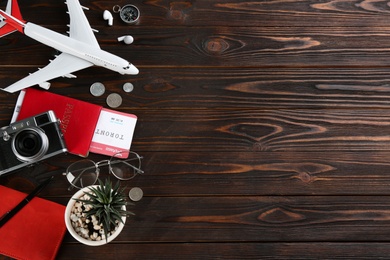 Flat lay composition with toy airplane and travel items on wooden background. Space for text