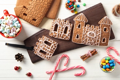 Photo of Flat lay composition with parts of gingerbread house on white wooden table