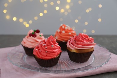 Photo of Delicious cupcakes with pink cream on grey table