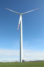 Photo of Modern wind turbine in field. Alternative energy source
