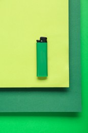 Stylish small pocket lighter on color background, top view