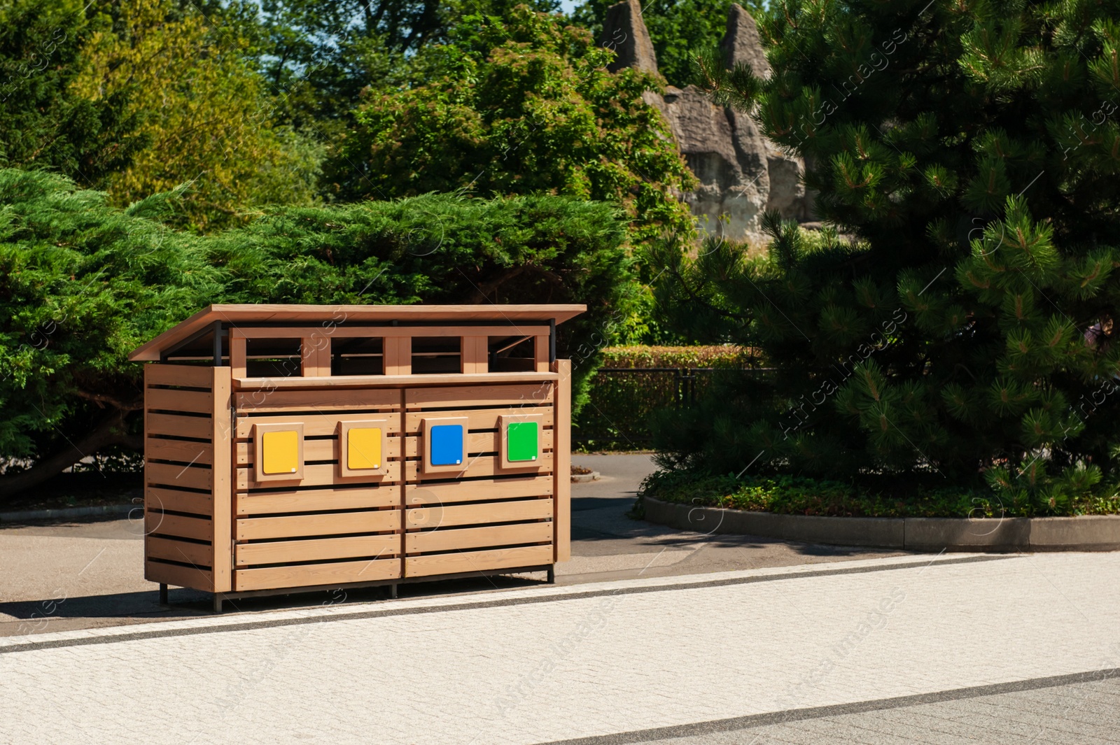 Photo of Wooden recycling bins for waste sorting outdoors