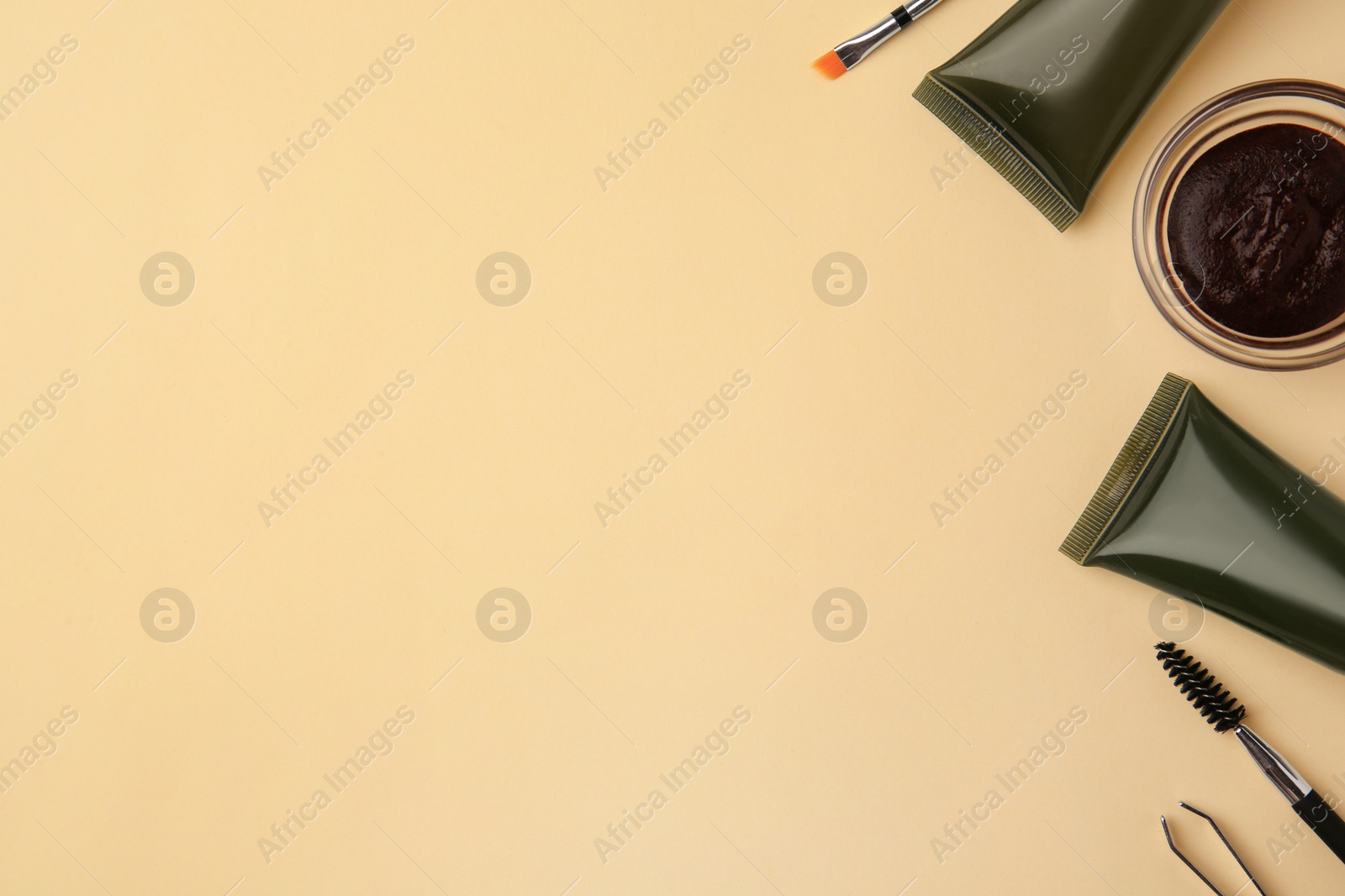 Photo of Flat lay composition with eyebrow henna and tools on beige background. Space for text