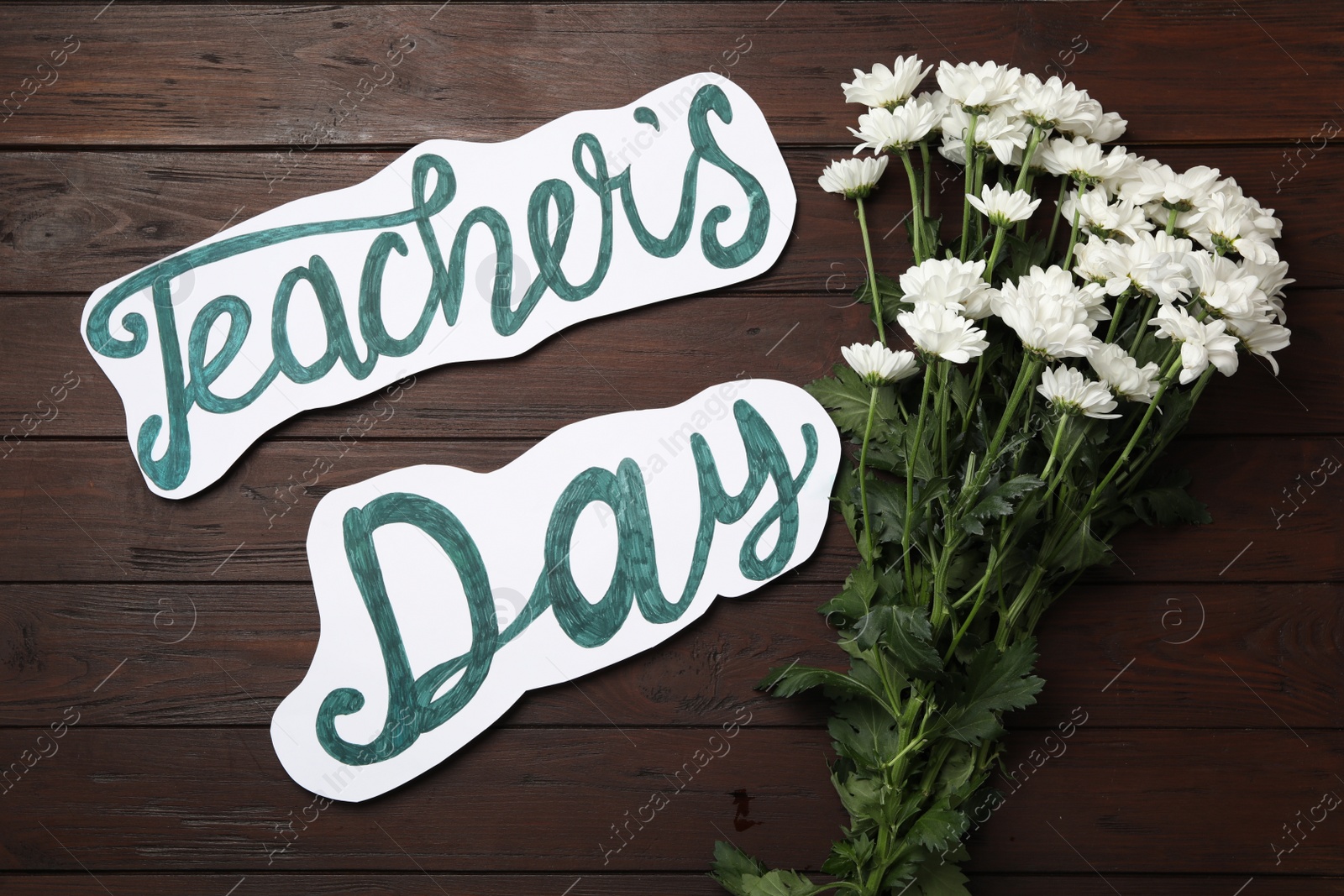 Photo of Words TEACHER'S DAY and chrysanthemum flowers on wooden table, flat lay