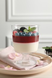 Photo of Delicious panna cotta with berries on light table