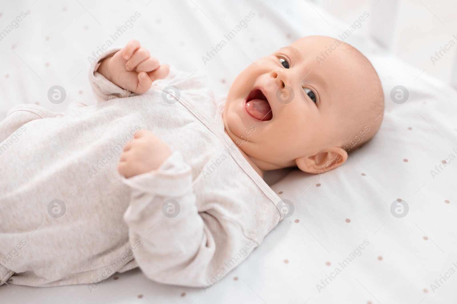 Photo of Cute little baby lying in crib at home