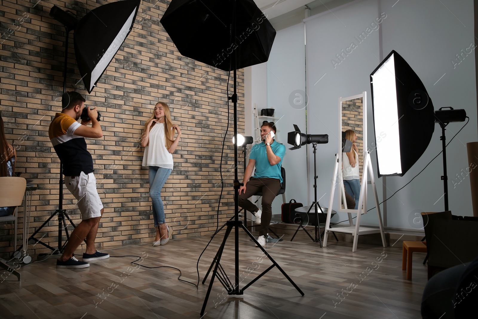 Photo of Professional team working with model in photo studio